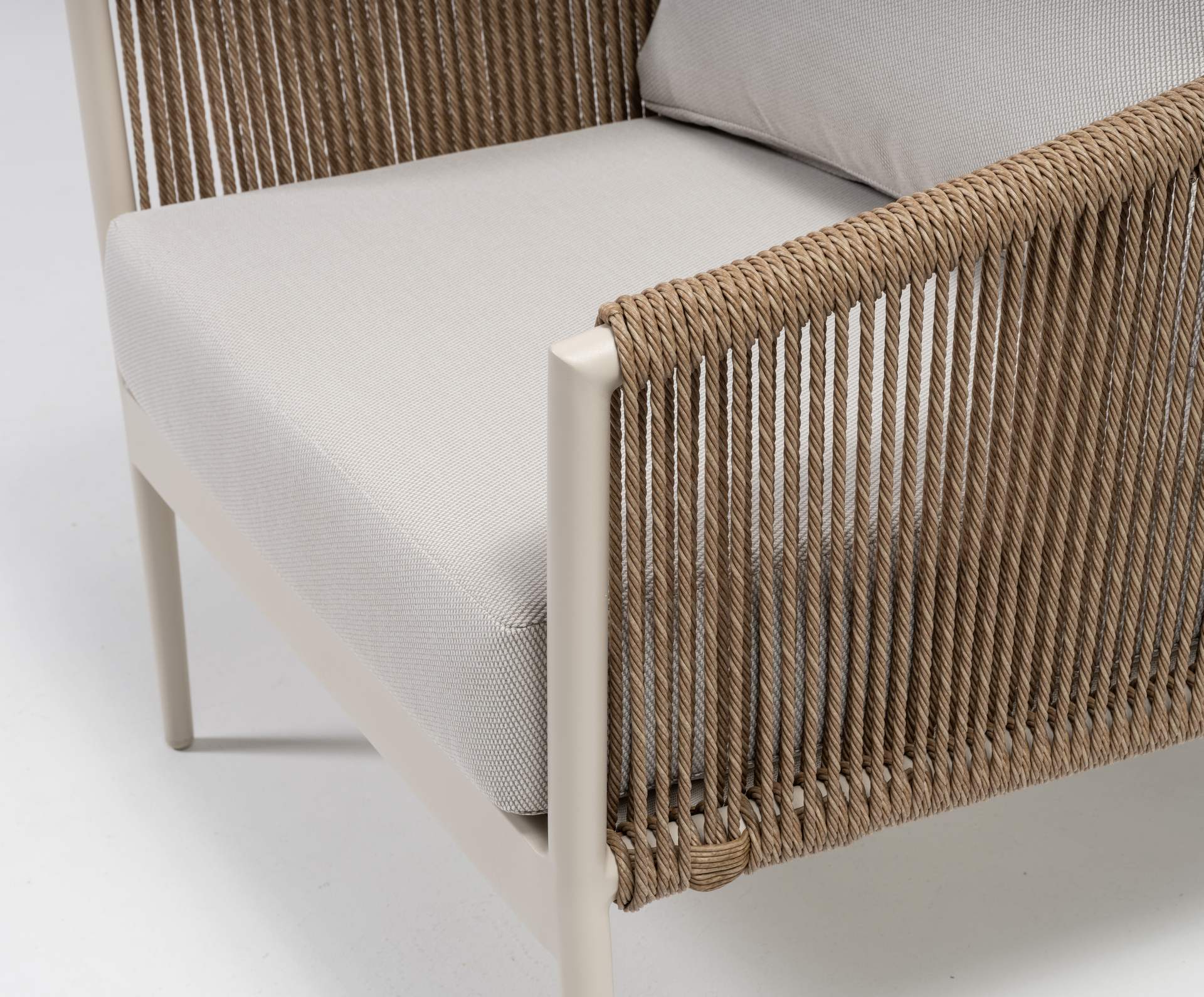 Loungegruppe Cassidy mit Aluminiumgestell in Ivory, sandfarbenen Textilschnüren, hellen Polstern und zwei Couchtischen.