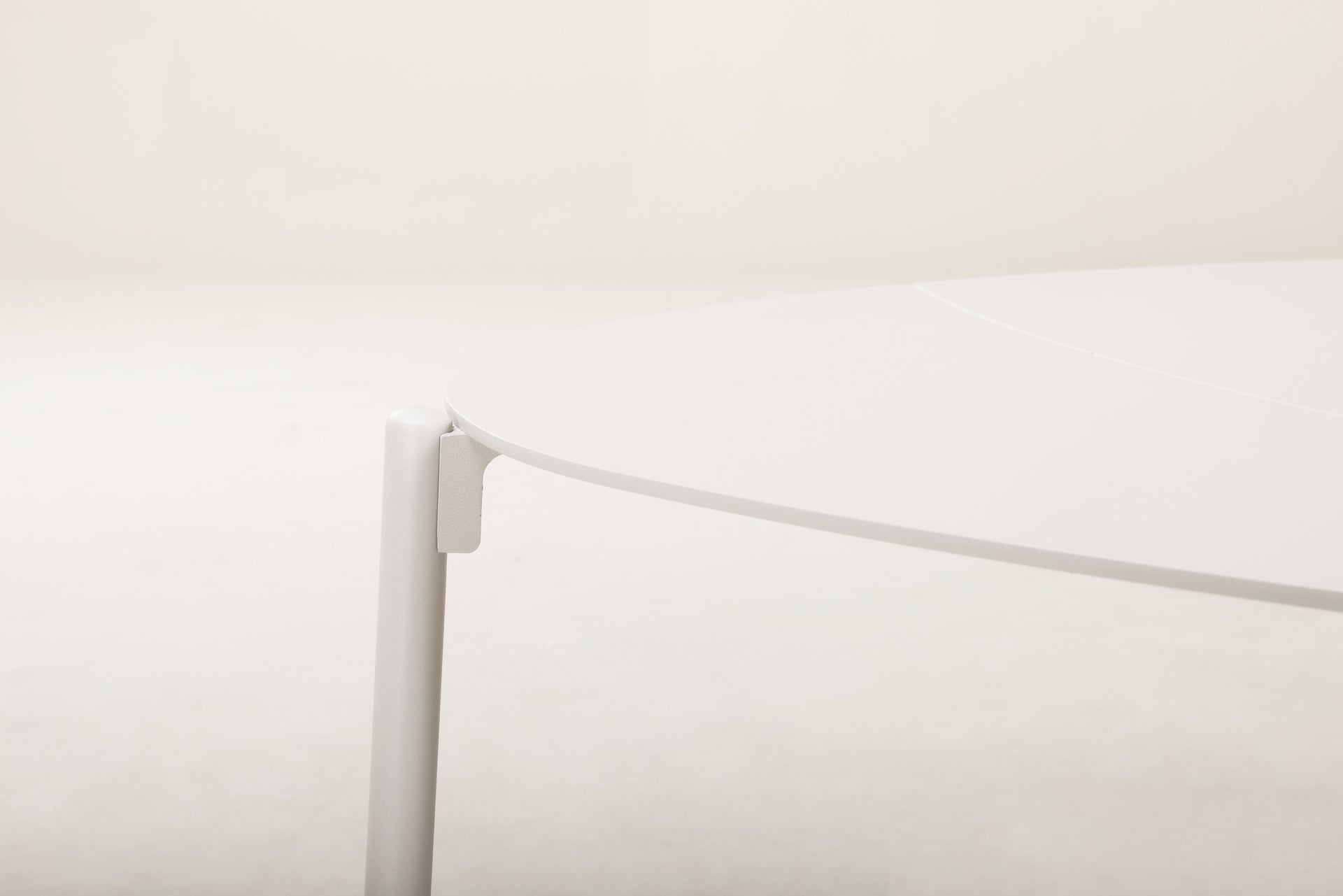 Loungeelemente Celeste mit ivoryfarbenem Aluminiumgestell, sandfarbenen Textilschnüren und hellgrauen Polstern. Ovaler und runder Couchtisch aus Aluminium.