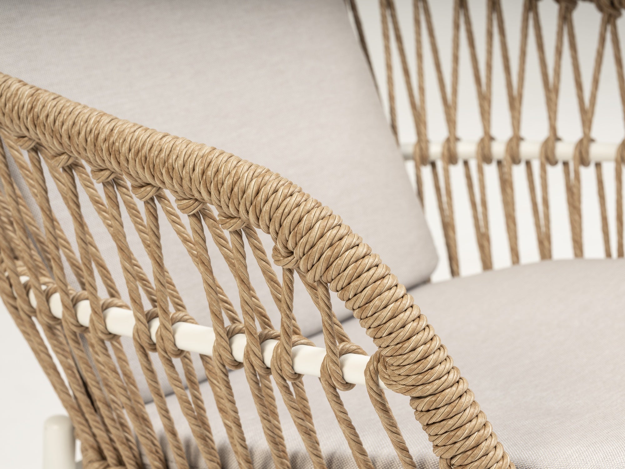 Stapelbarer Benito Gartenstuhl mit naturfarbenen Kunststoffschnüren und weißem Aluminiumgestell, bereit, Stil und Komfort in Ihren Außenbereich zu bringen.