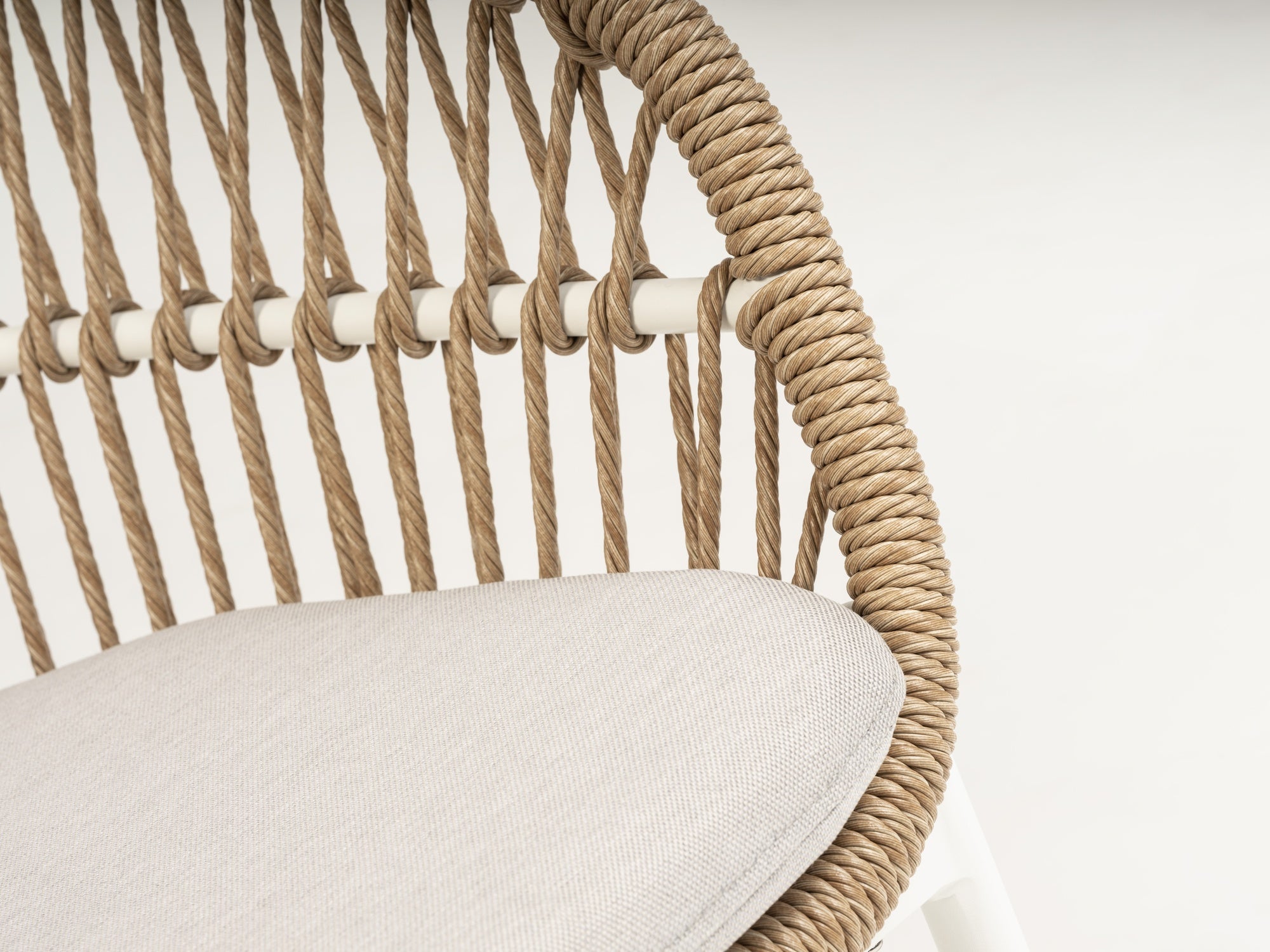 Stapelbarer Benito Gartenstuhl mit naturfarbenen Kunststoffschnüren und weißem Aluminiumgestell, bereit, Stil und Komfort in Ihren Außenbereich zu bringen.