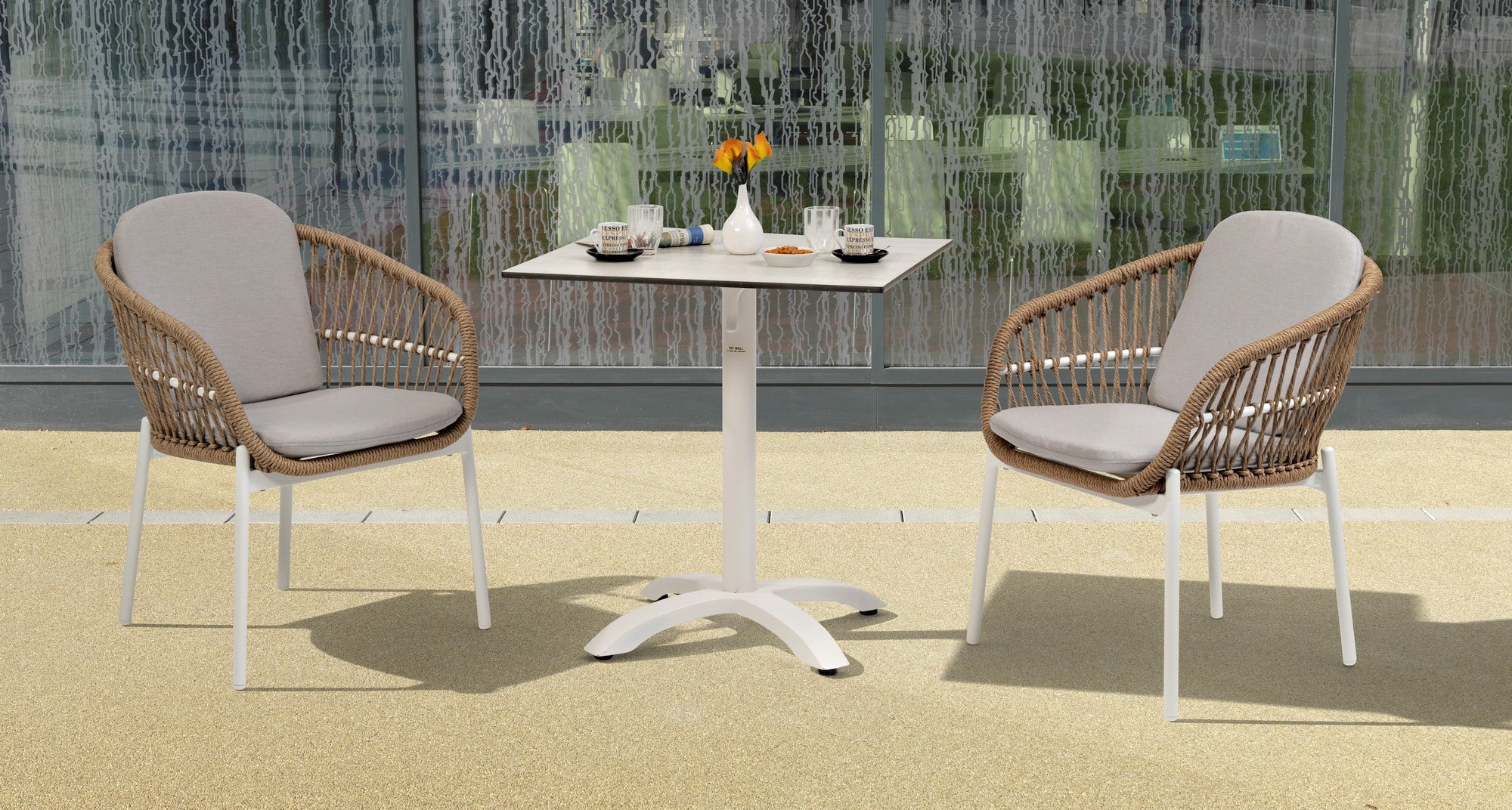 Stapelbarer Benito Gartenstuhl mit naturfarbenen Kunststoffschnüren und weißem Aluminiumgestell, bereit, Stil und Komfort in Ihren Außenbereich zu bringen.