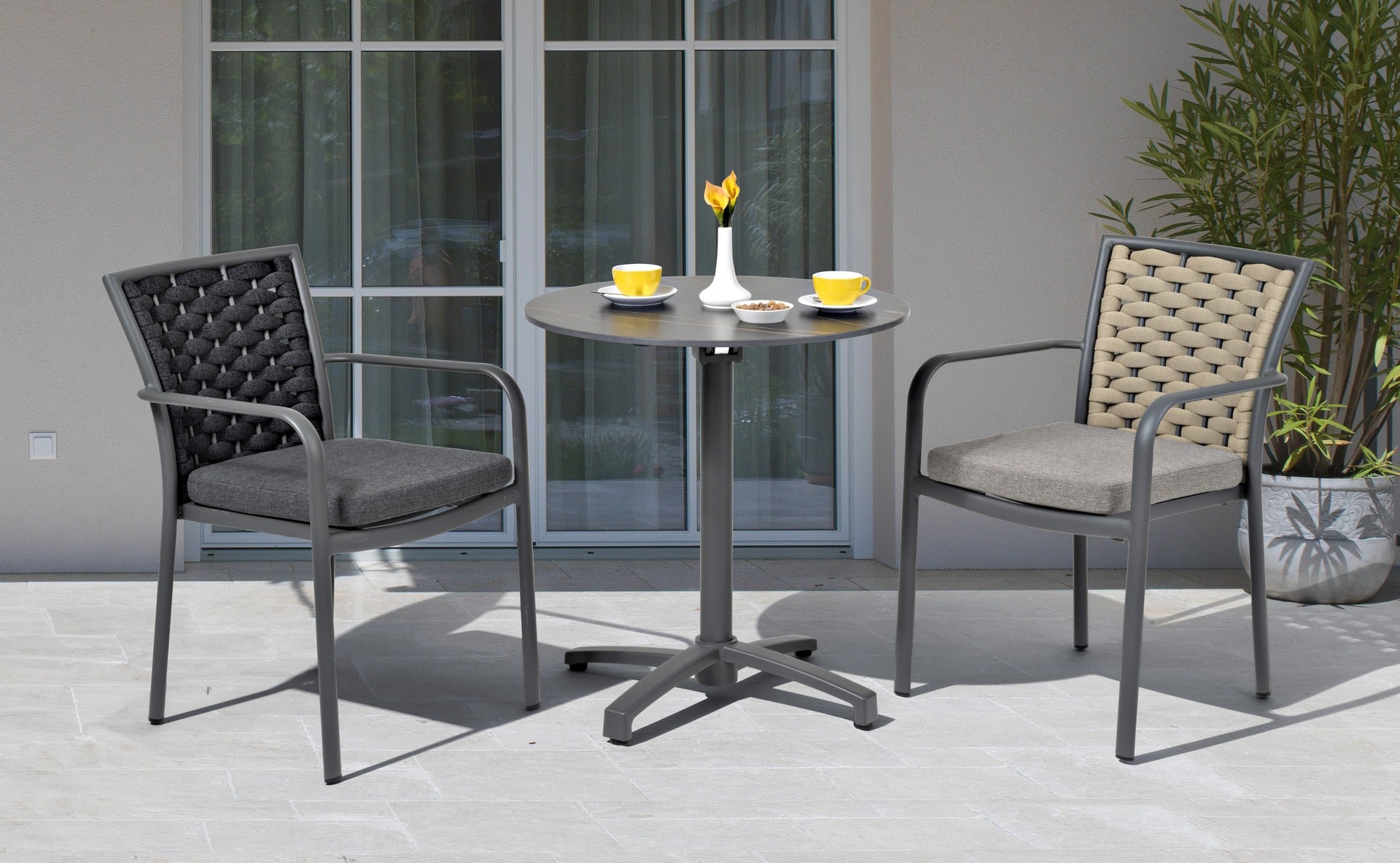 Stilvoller 'Clara' Armstuhl mit Metallgestell und Schnüren, schnell trocknenden Textilschnüren, gepaart mit einem bequemen grauen Sitzkissen, angeboten von Gartenmoebelshop.at - Beide Farben nebeneinen auf einer Terrasse