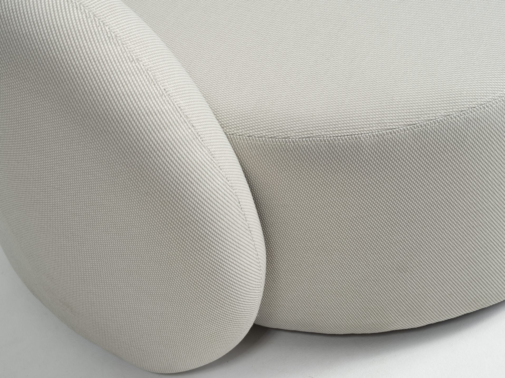 Modernes Letizia Garten-Sofa in Creme mit wasserabweisendem Axroma-Stoff und zahlreichen Rückenkissen, arrangiert auf einer Holzterrasse mit einem eleganten weißen Beistelltisch, präsentiert als ideale Ergänzung für stilvolles Outdoor-Entspannen.