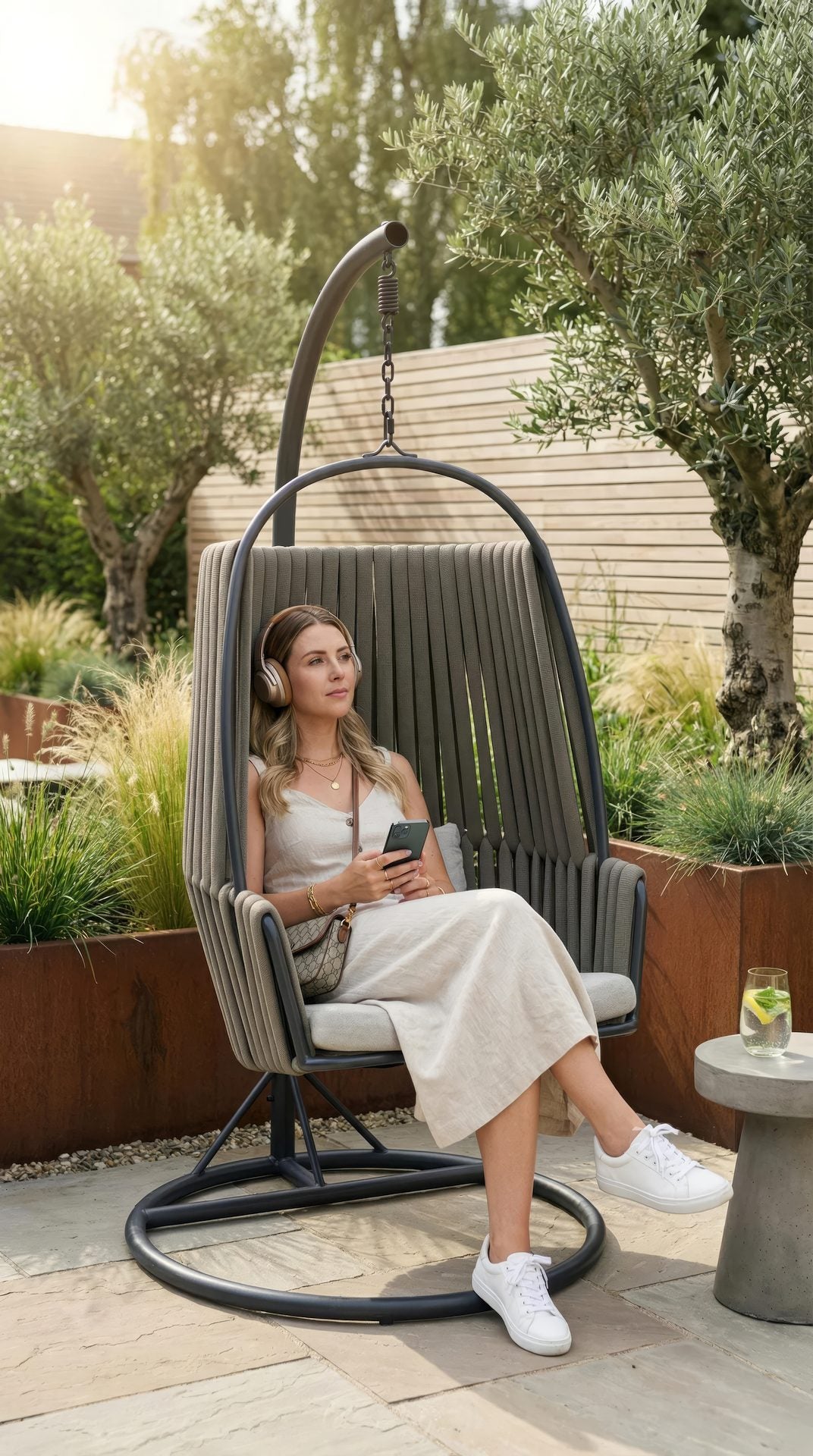 Hängekorb Nero mit Stahlgestell und geflochtenen Textilenschnüren in Grau, inklusive komfortabler Polster in hellem Grau.