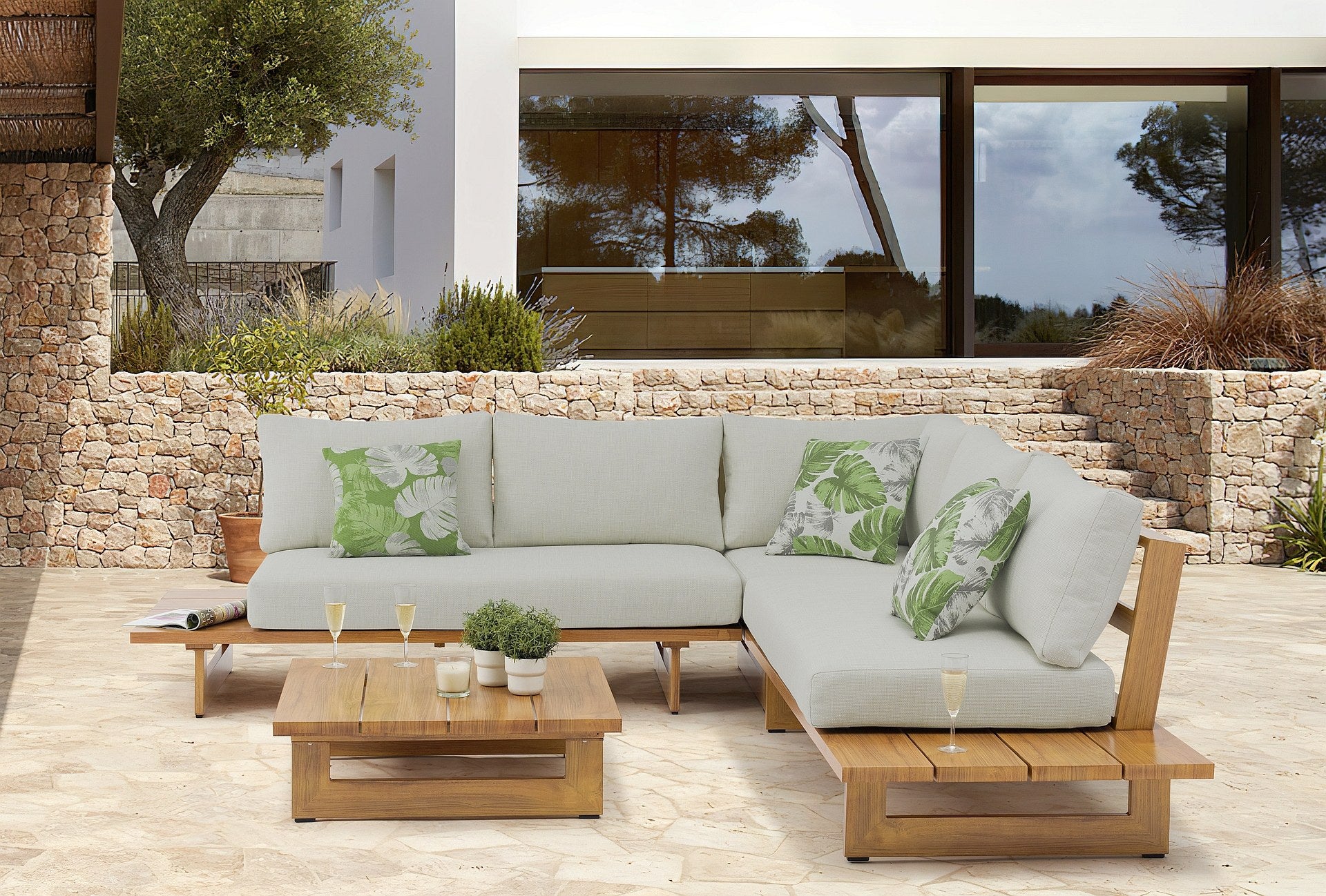 Moderne Alina Garten Lounge Gruppe mit Eckbank und Couchtisch in täuschender Holzoptik aus Aluminium und hellgrauen Kissen, perfekt für stilvolles Entspannen im Freien, erhältlich bei Gartenmöbelshop.at.